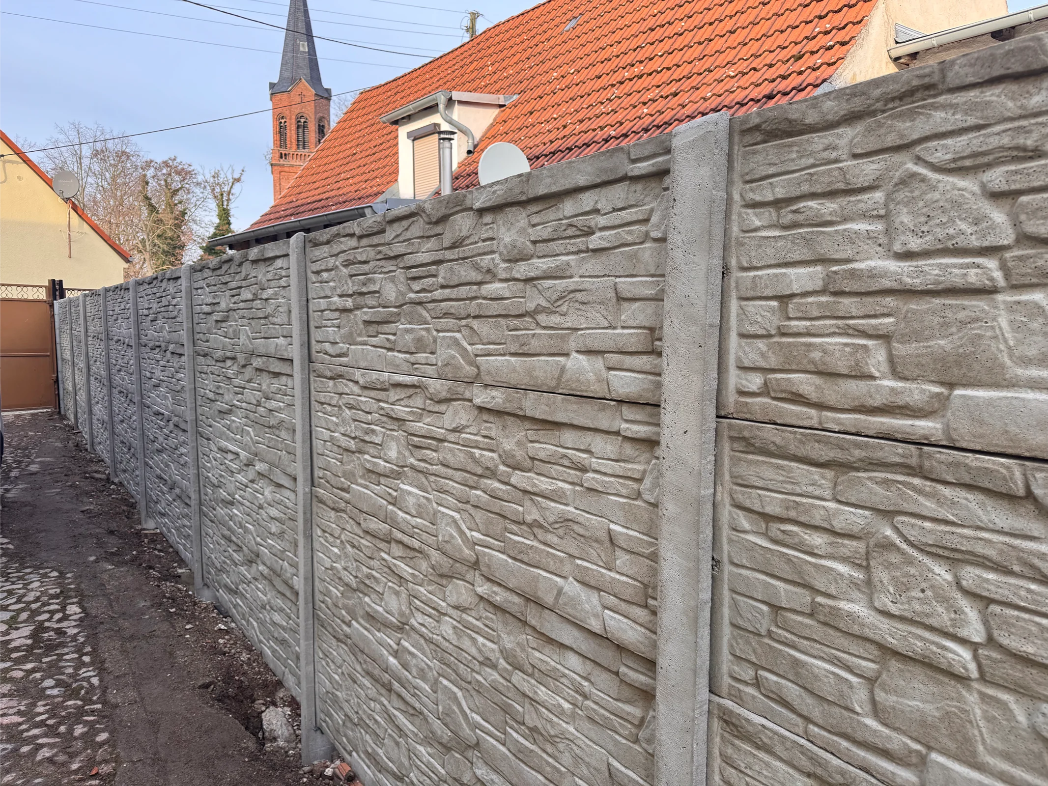 Betonzaun mit Steinstruktur