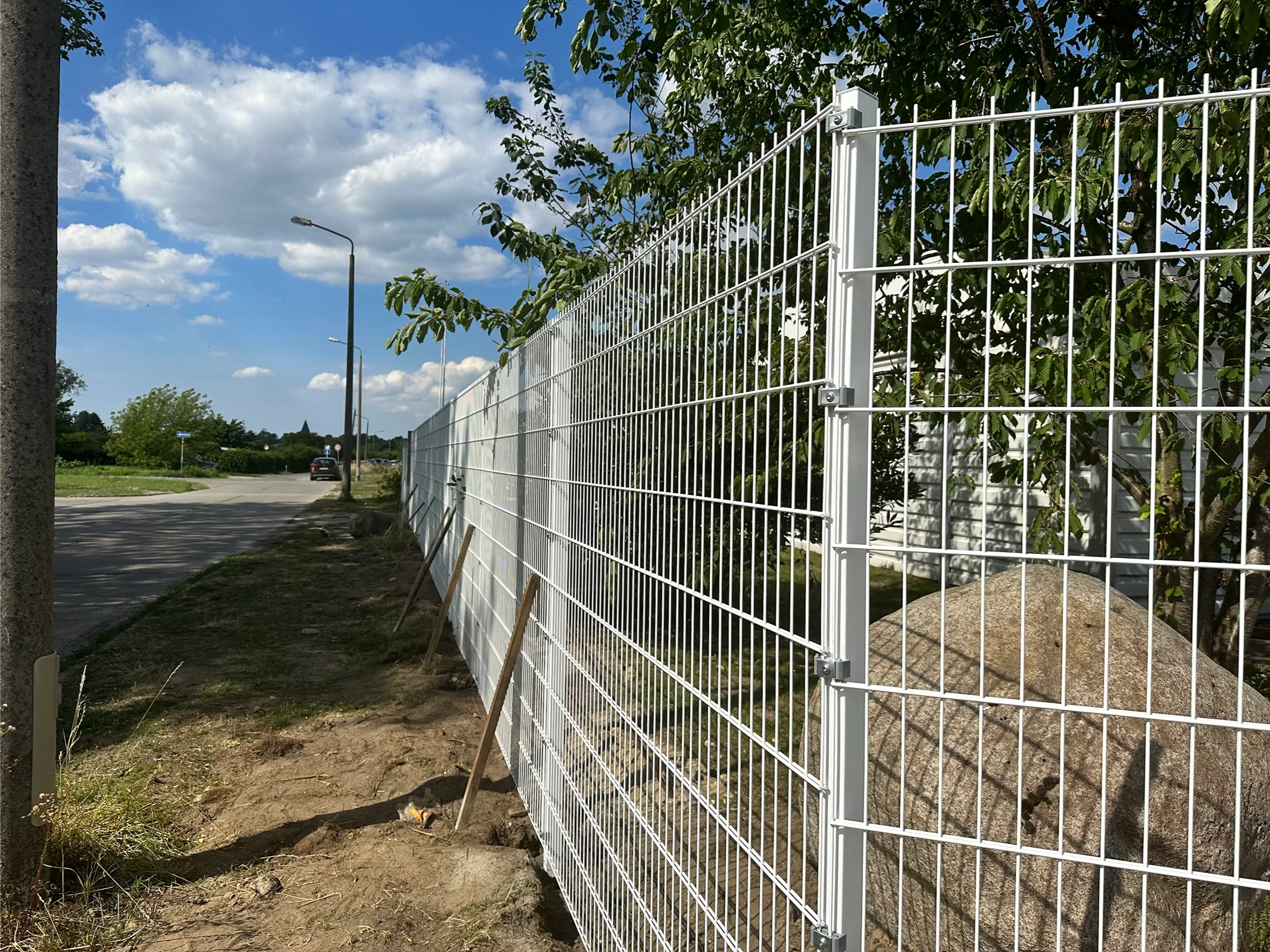 Weiße Metallzaunanlage mit Tor