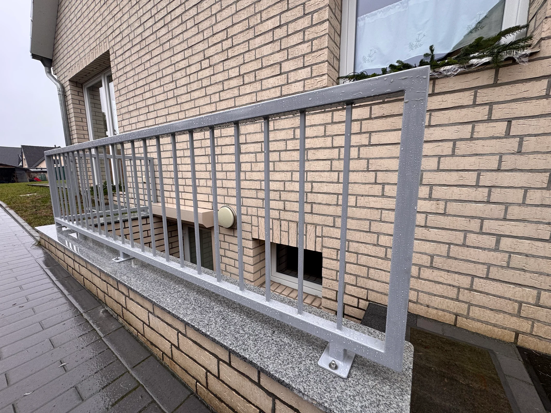 Modernes Stahlgeländer an Ziegelfassade