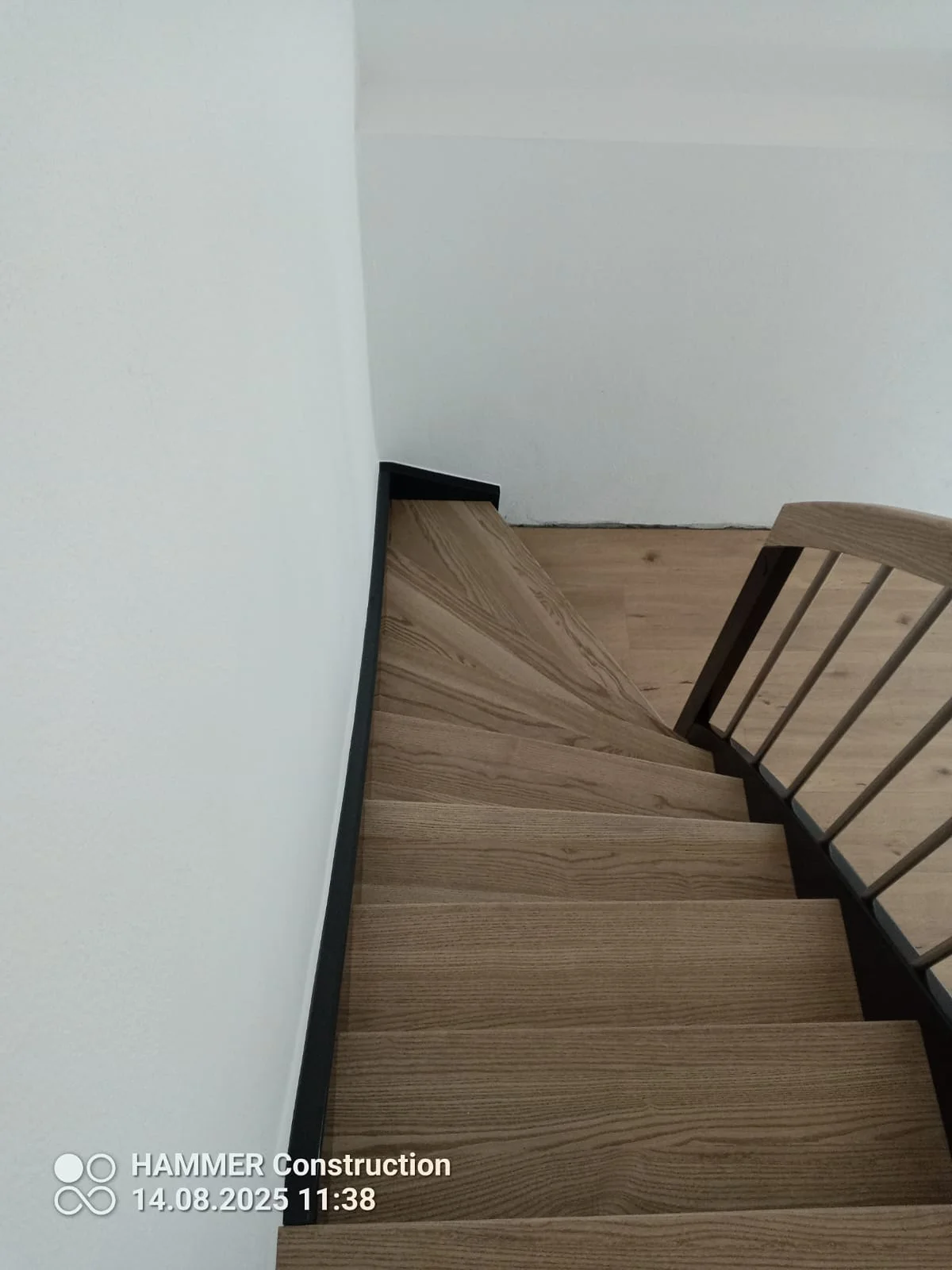 Moderne Holztreppe mit schwarzem Metallgeländer