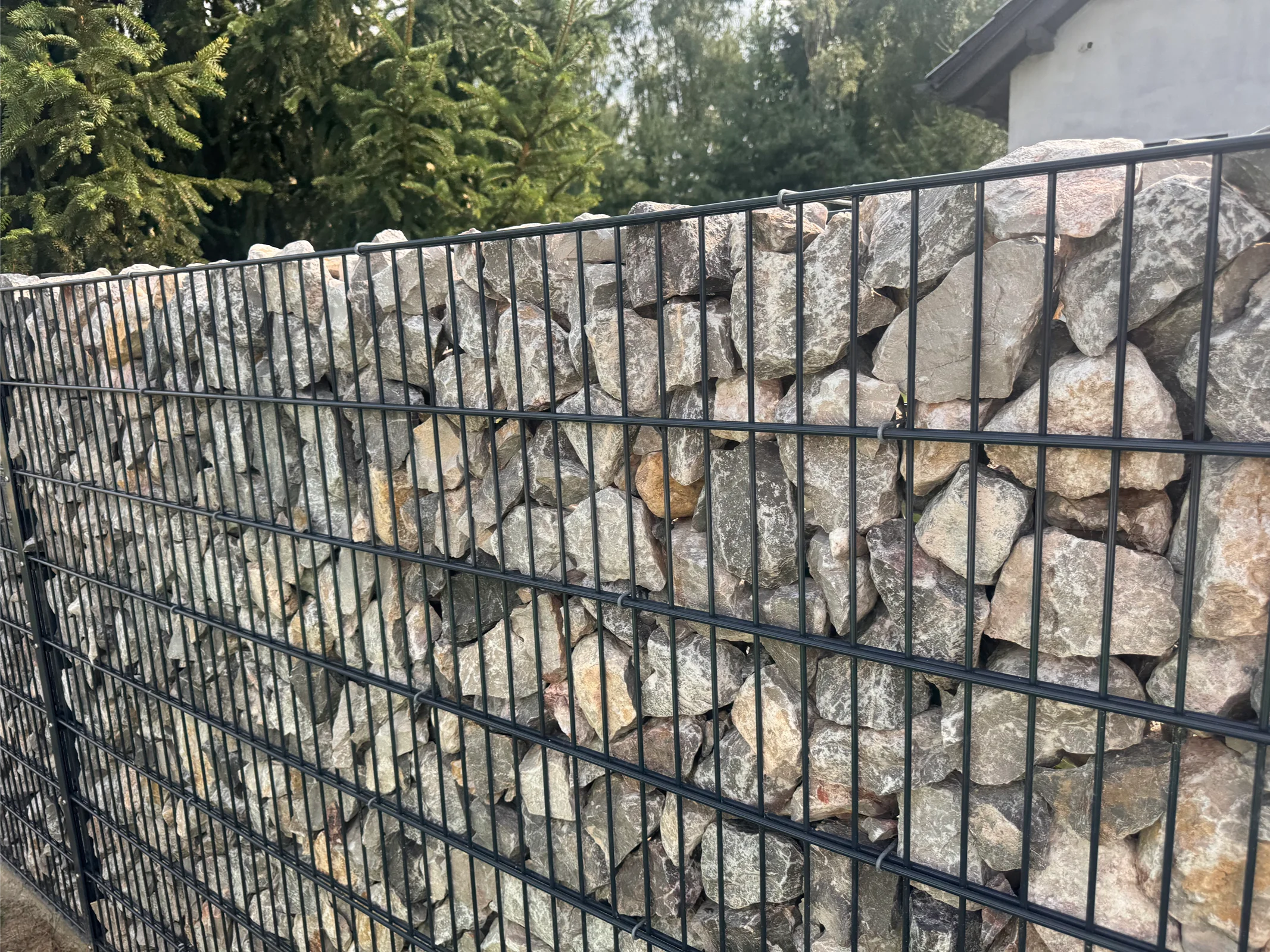 Moderner Metallzaun mit Steinwand