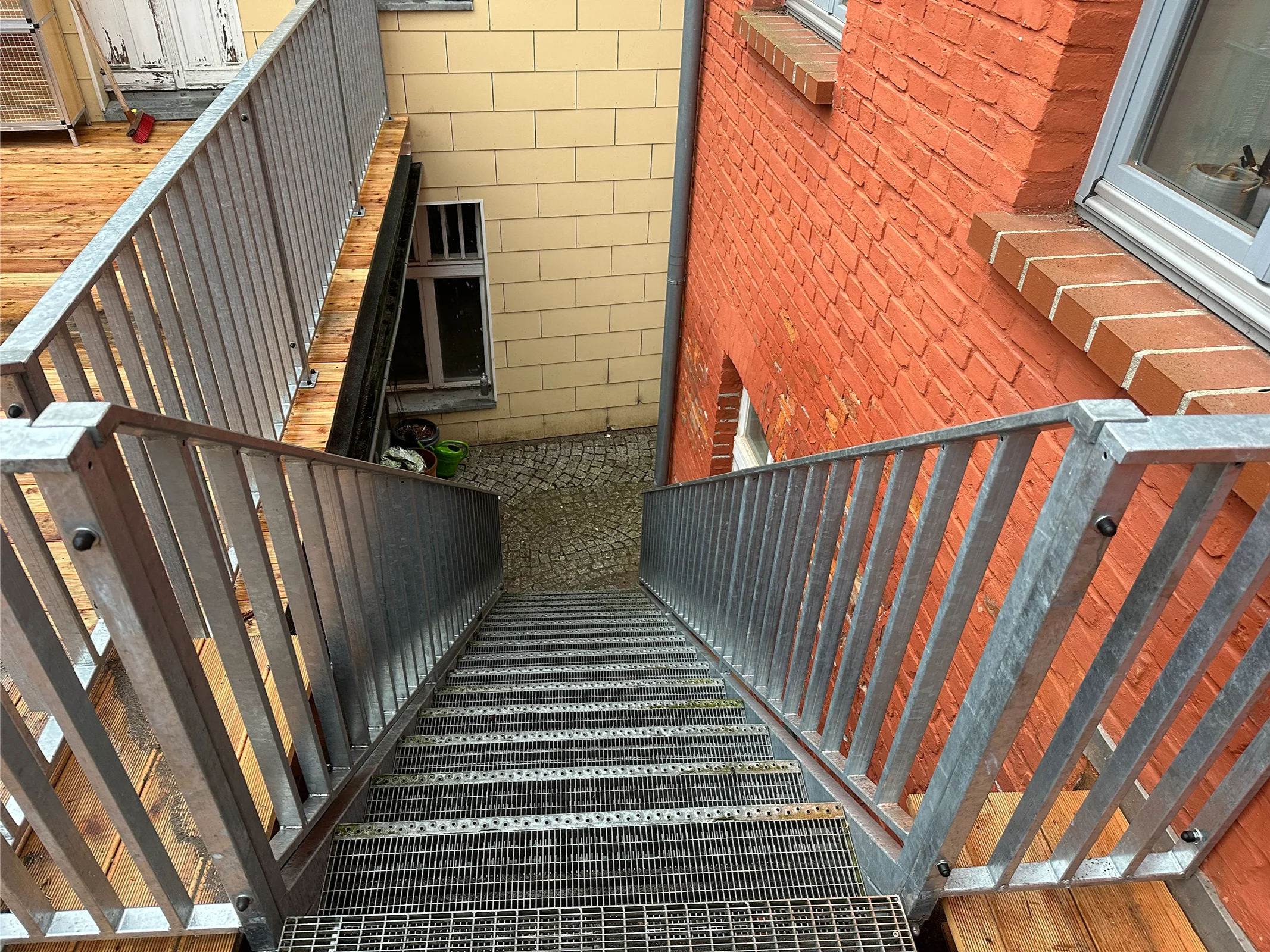 Stahltreppe mit Metallgittern zwischen Häusern