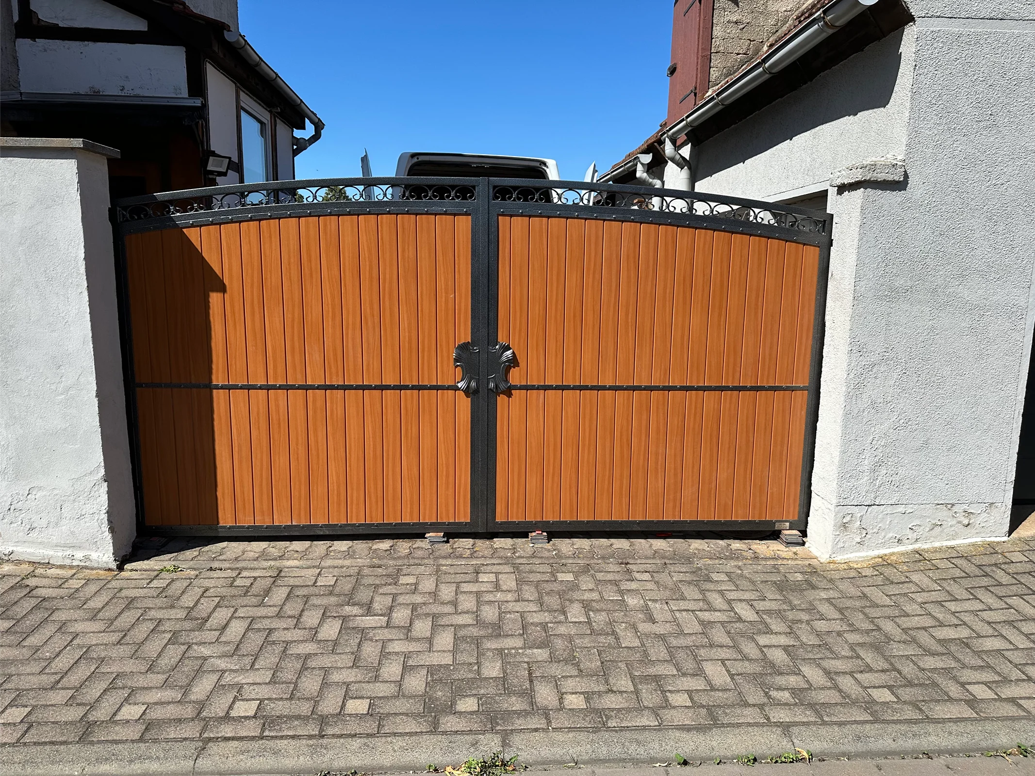 Doppeltor mit orangefarbenen Latten und schwarzem Rahmen