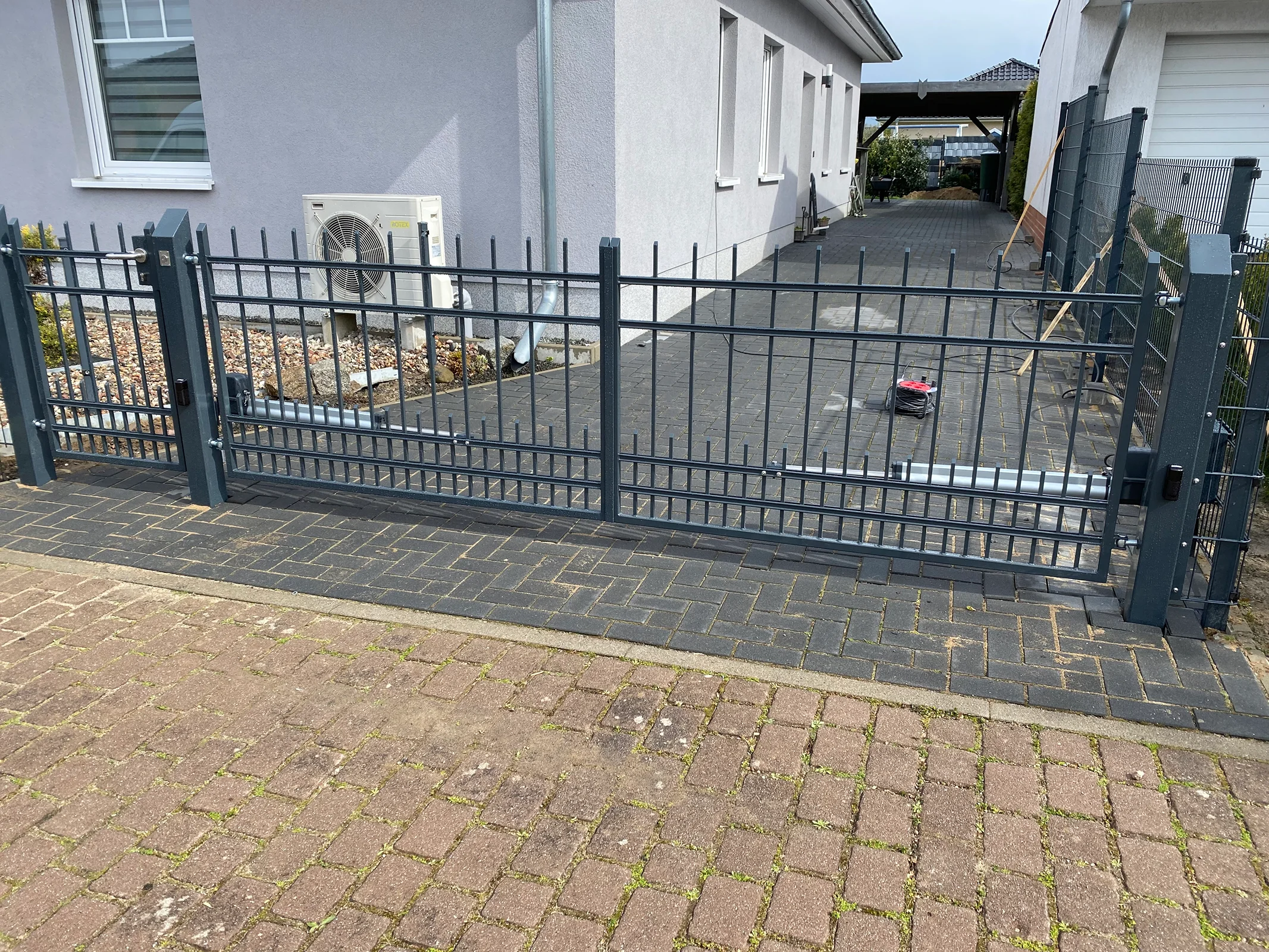 Modernes schwarzes Einfahrtstor mit Metallgitter
