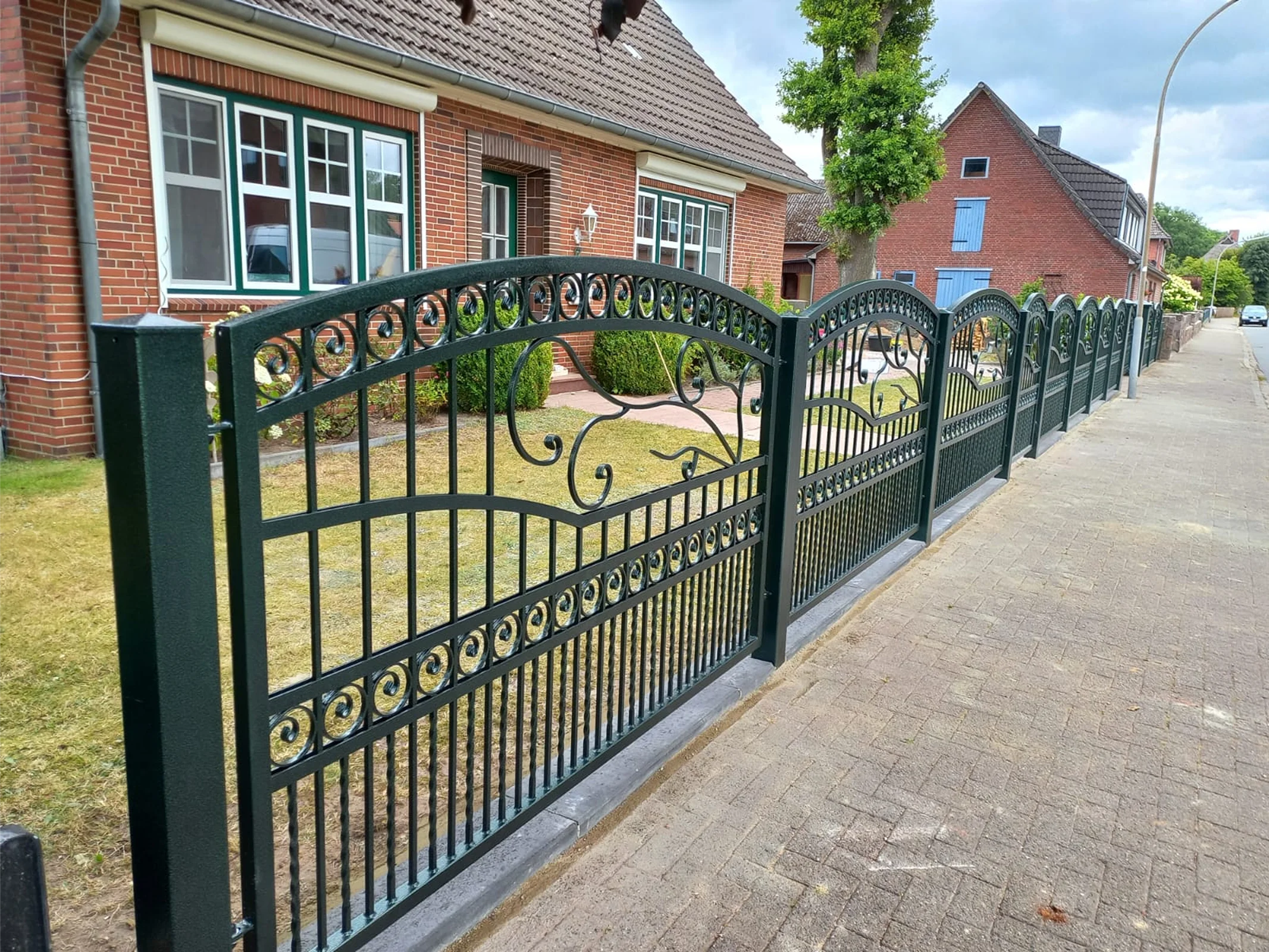 Ornamentales schwarzes Schmiedeeisentor mit goldenen Verzierungen