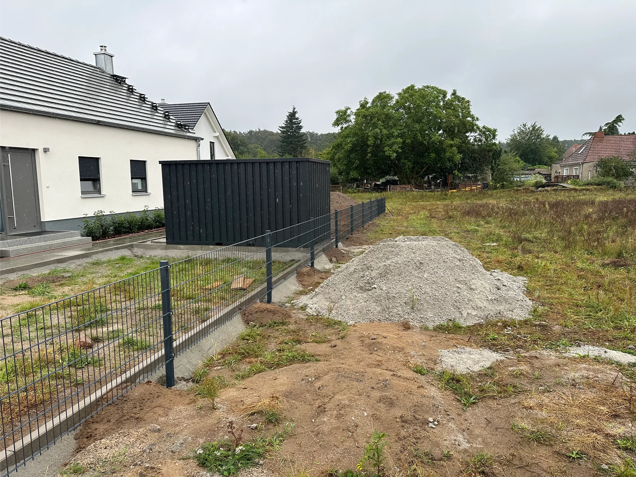 Modernes Wohnhaus mit schwarzem Wellblechzaun