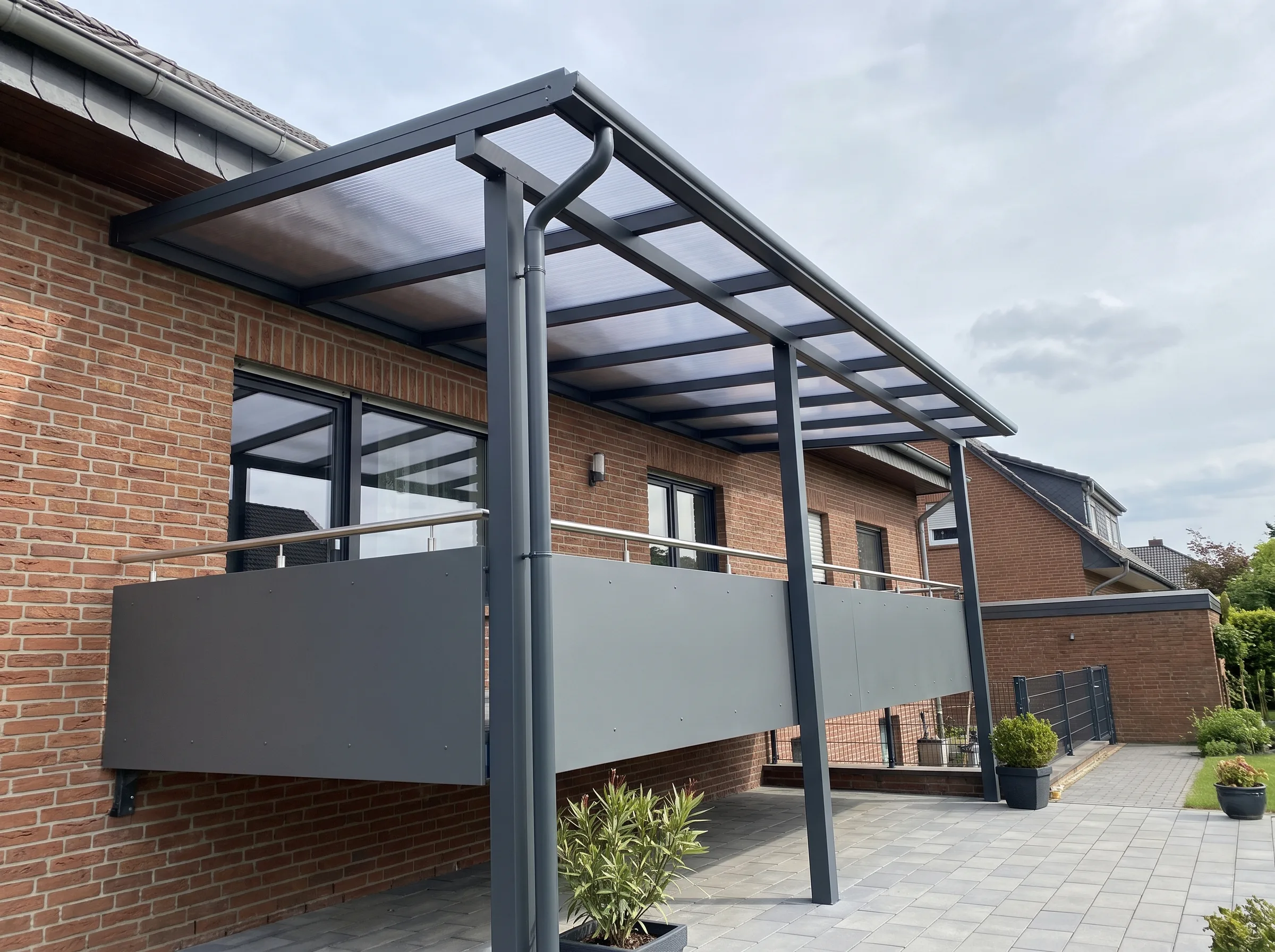 Moderne Überdachung über Terrasse mit Stahlkonstruktion und großen Fenstern