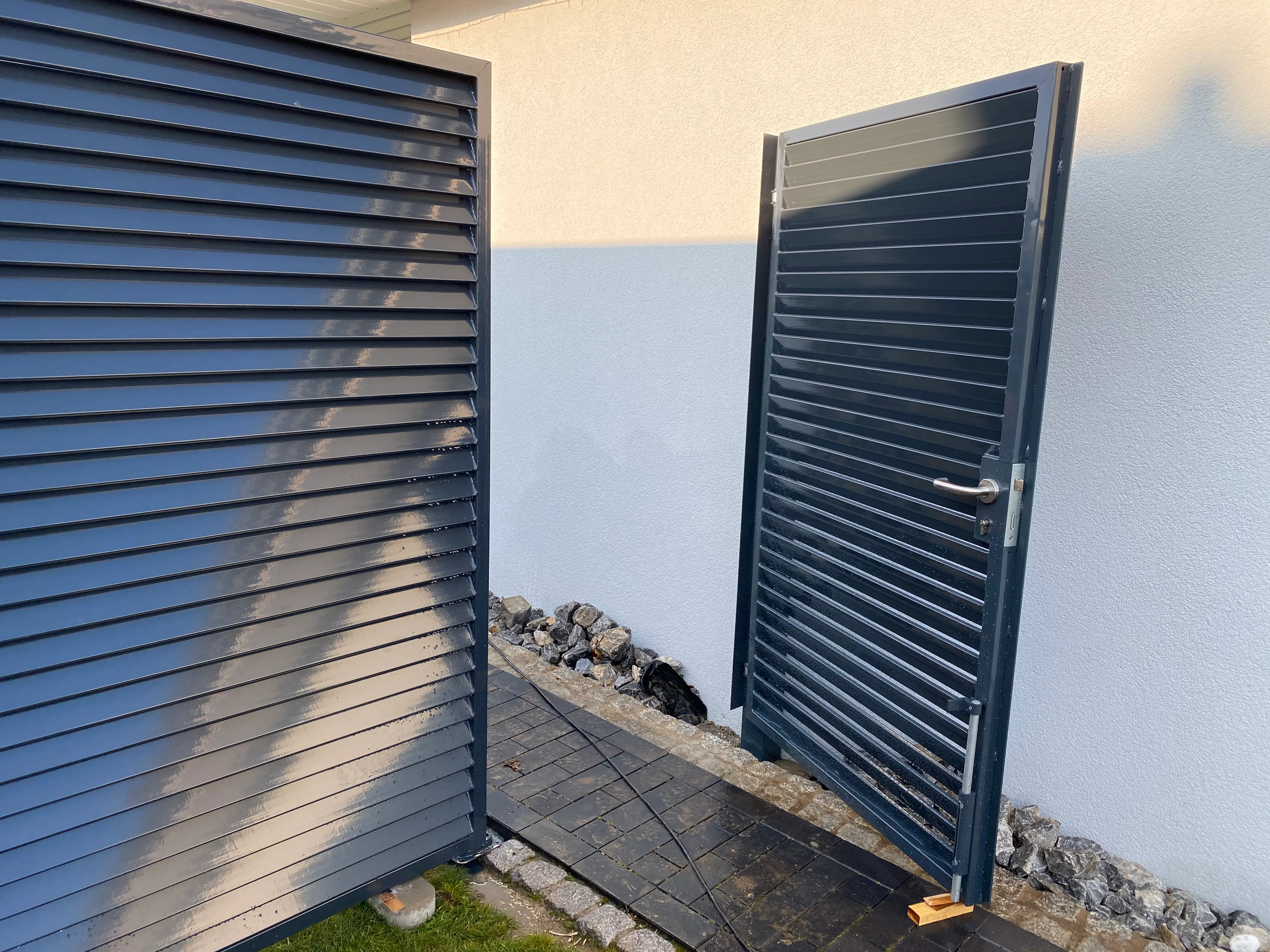 Modernes Gartentor und Sichtschutzzaun aus Metall in einer modernen Umgebung
