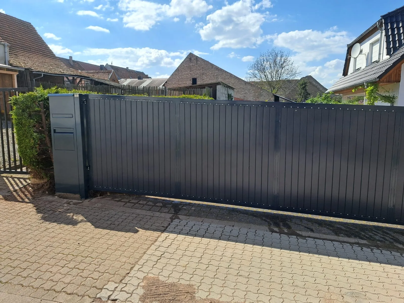 Modernes Gartentor aus Aluminium mit Sichtschutz, eingebaut in eine Wohngegend