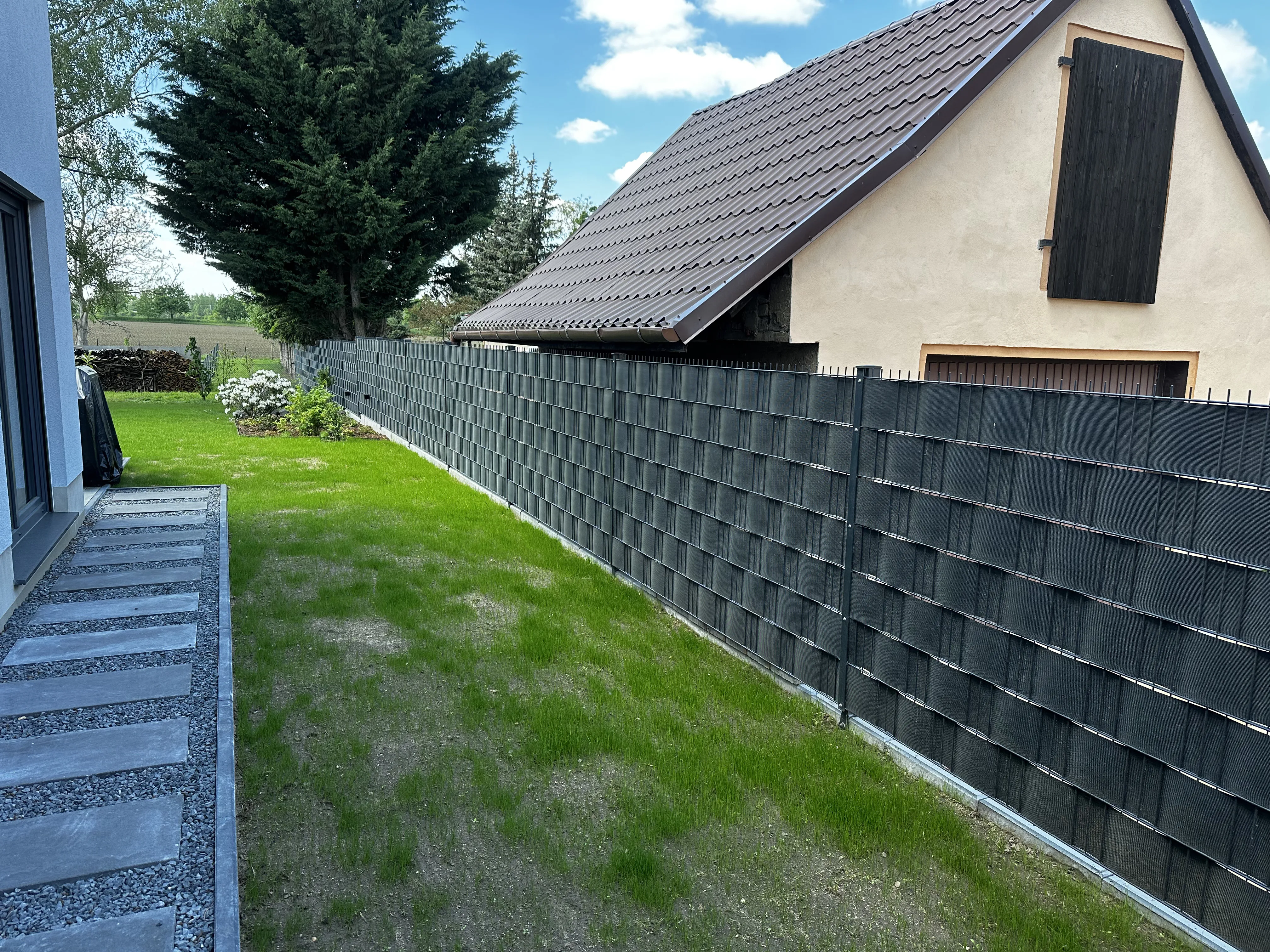 Blick auf einen modernen Sichtschutzzaun aus Doppelstabmatten in einem Garten
