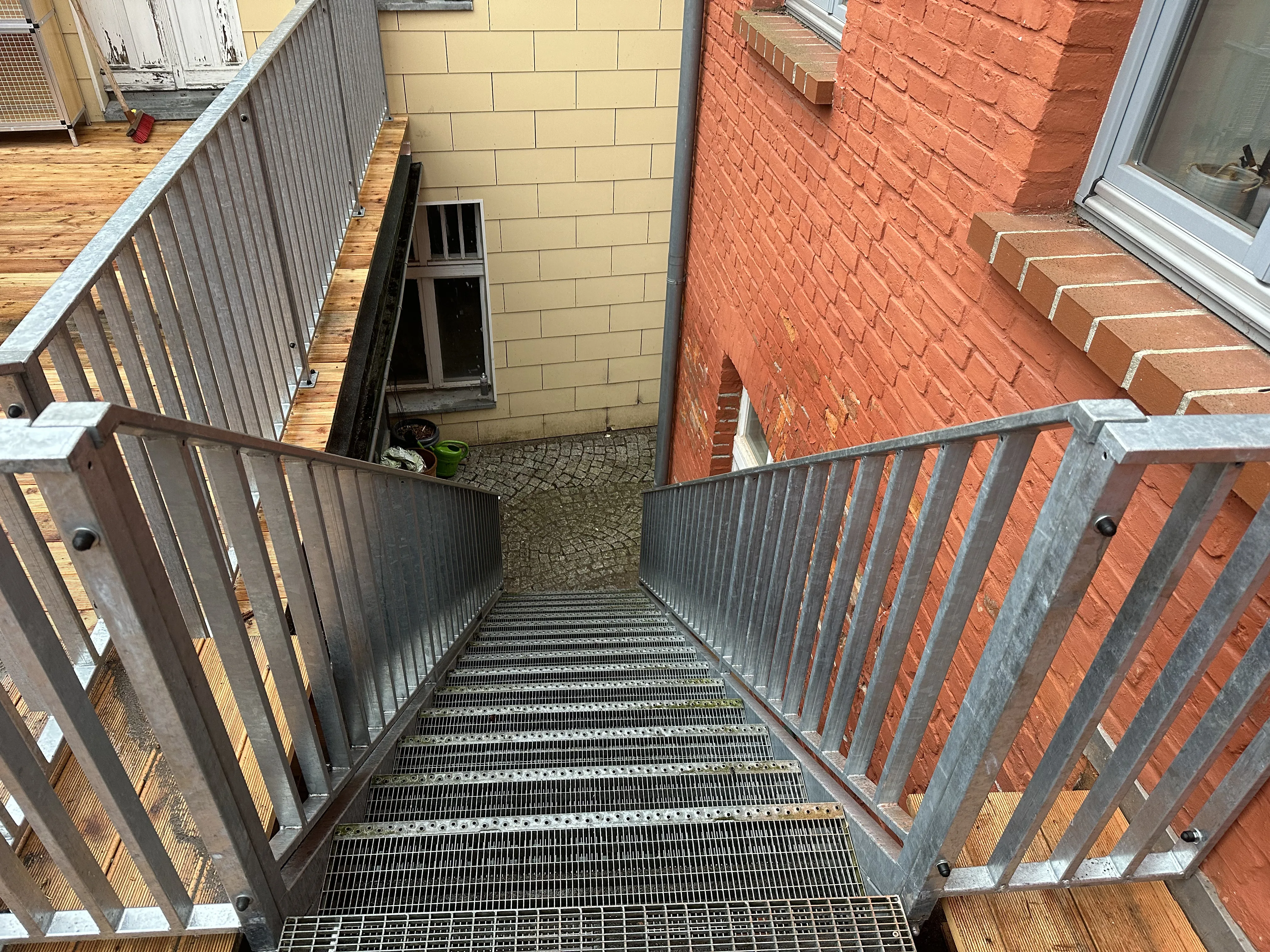Außentreppe mit Geländer aus Stahl und Holzboden in einem modernen Ambiente