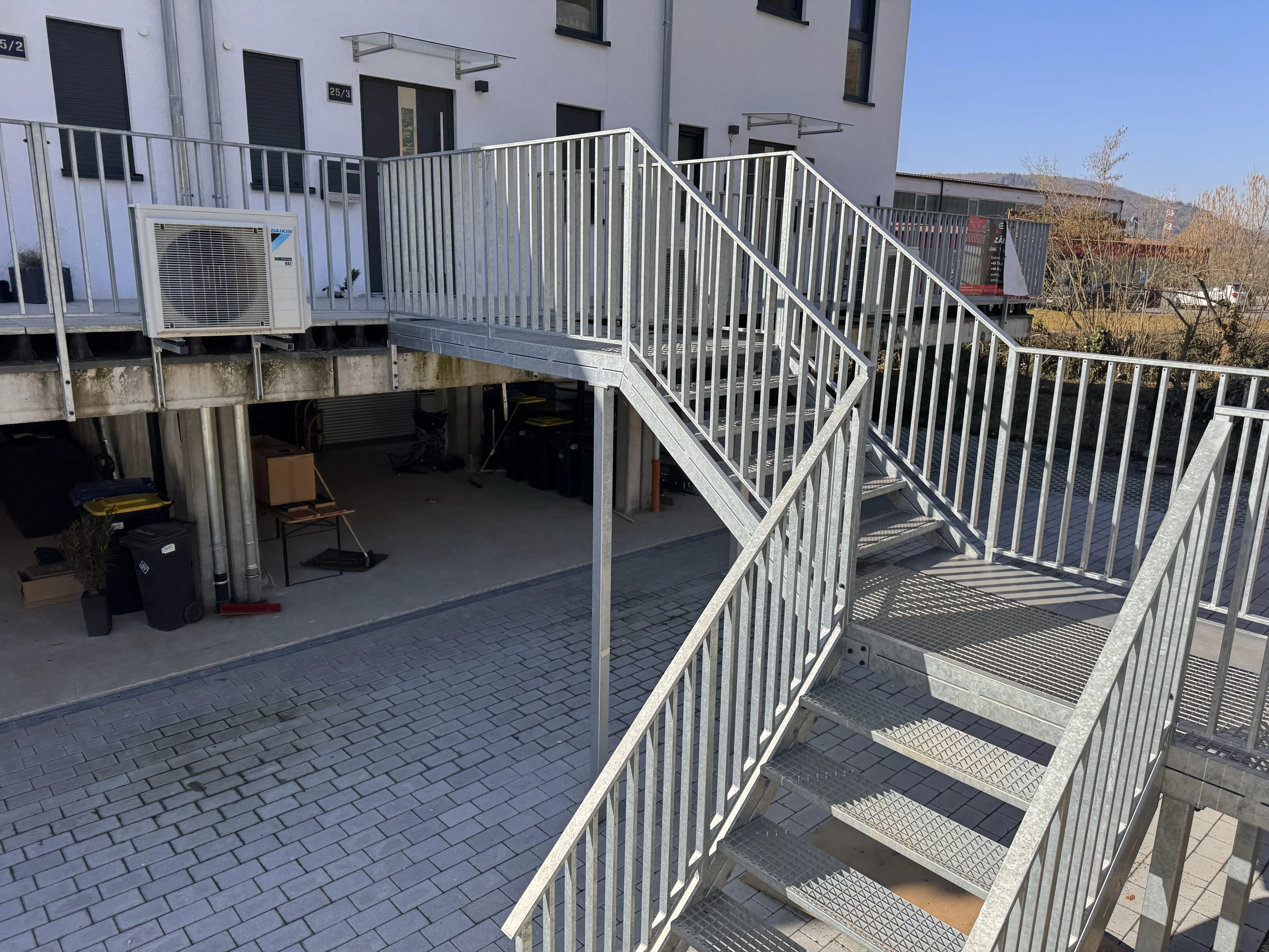 Sicht auf eine moderne Stahltreppe und einen gepflasterten Bereich