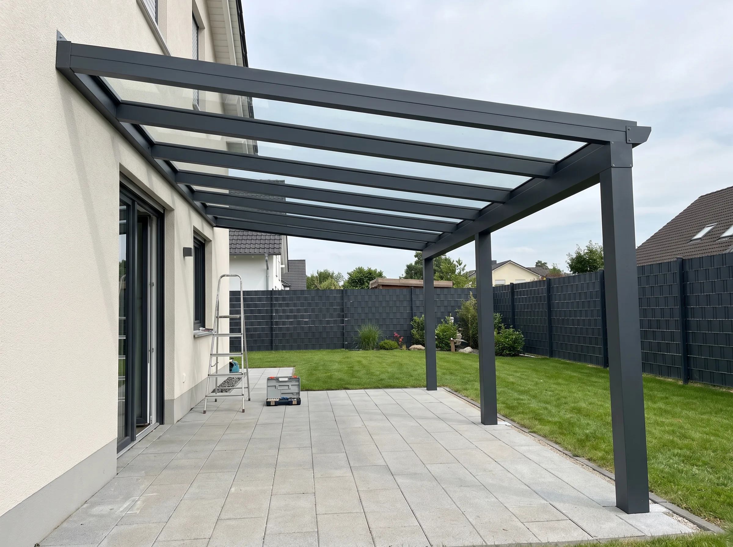 Moderne Terrassenüberdachung aus Stahl mit Glasdach, gestützt von stabilen Pfosten