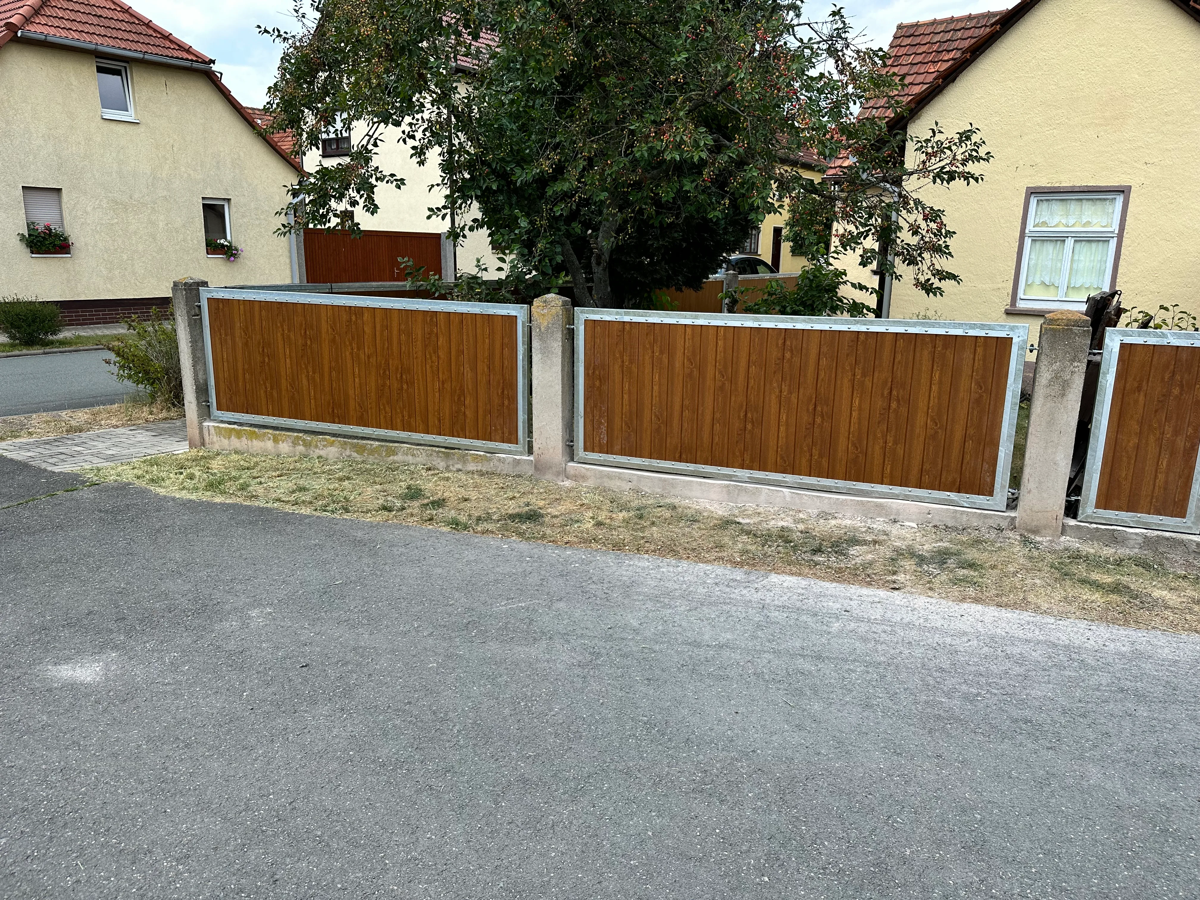 Moderner Sichtschutzzaun aus WPC mit Betonpfosten im Garten