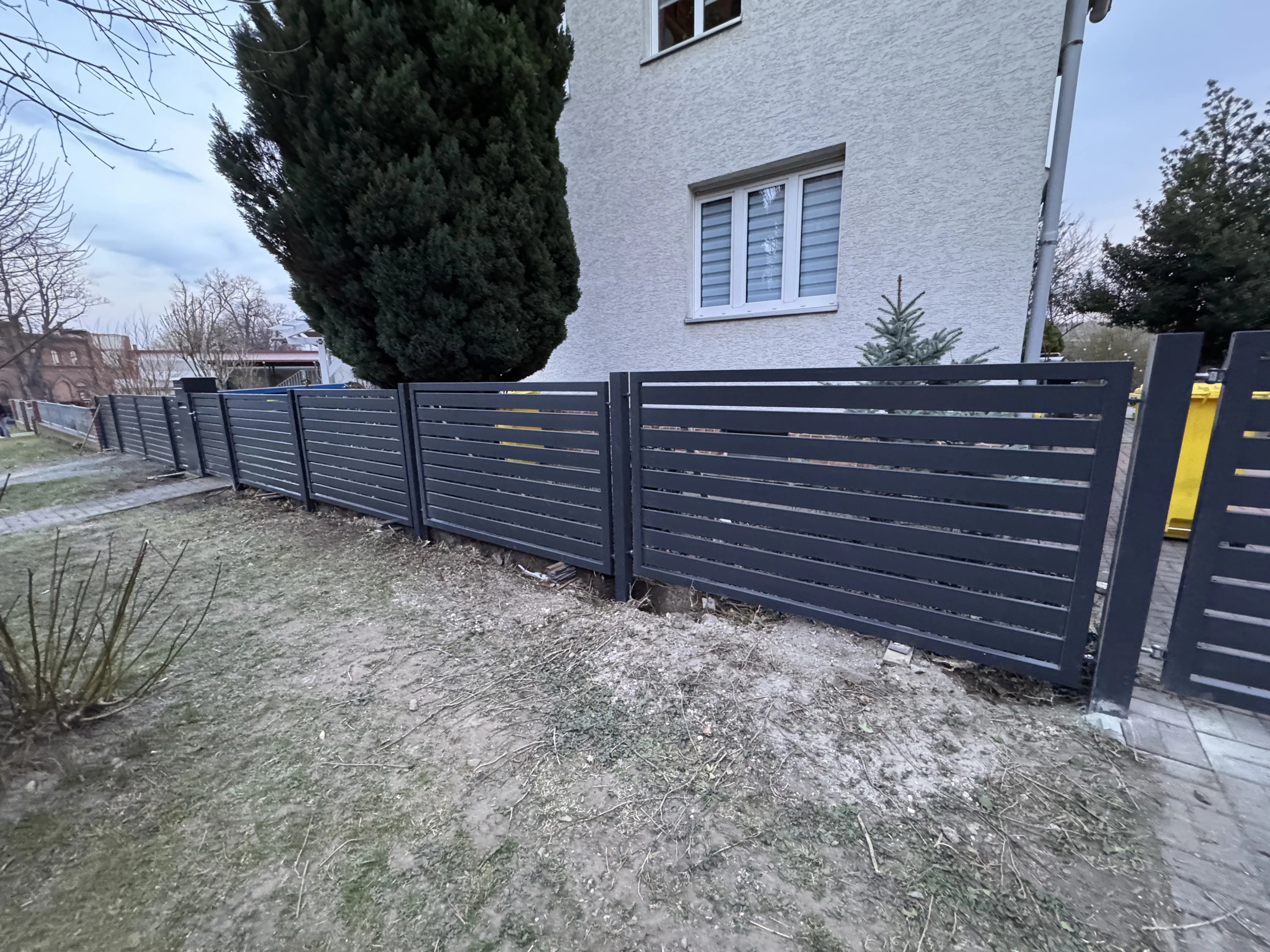 Moderner Sichtschutzzaun aus WPC umgibt einen Gartenbereich